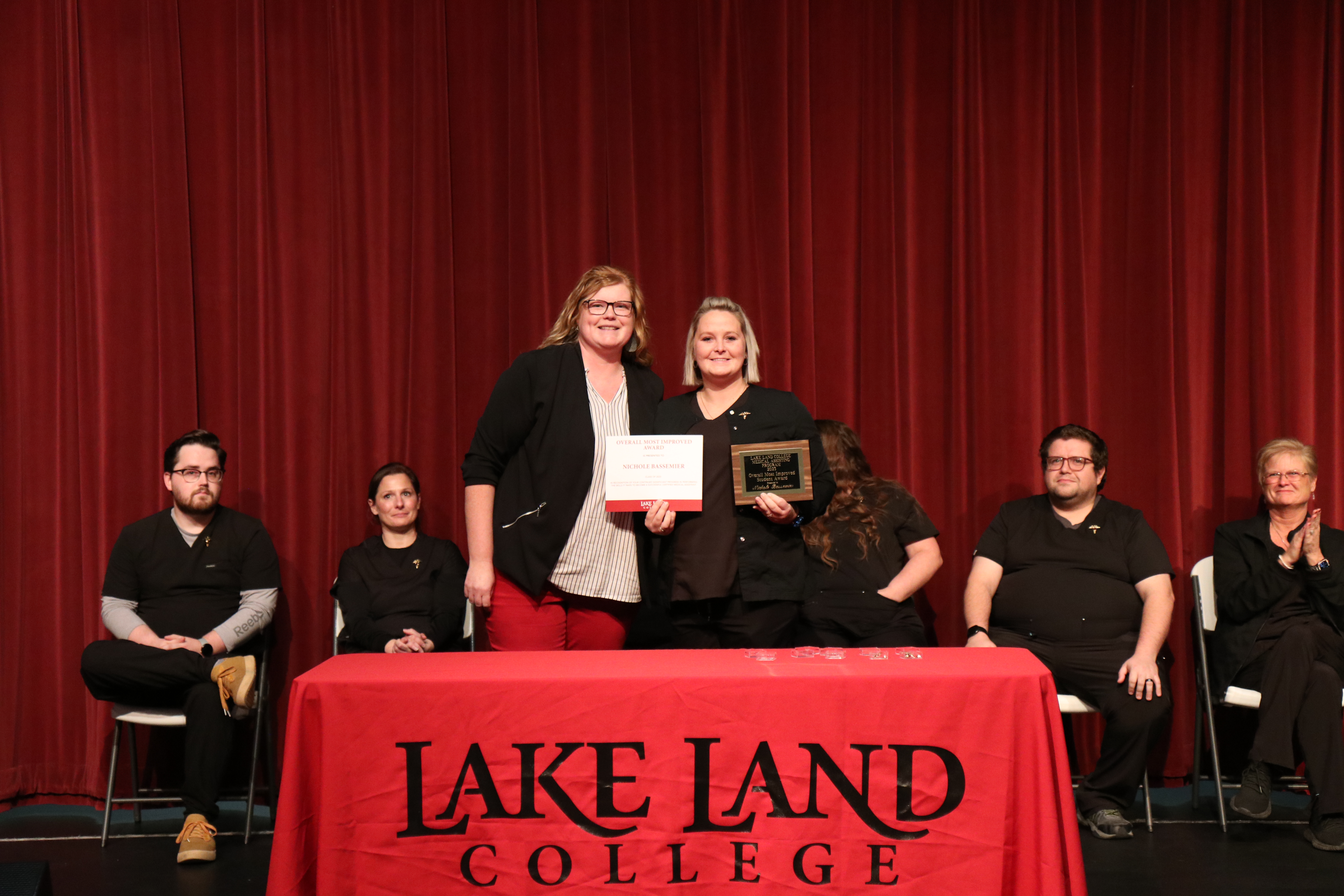 Medical Assistant Instructor presents an award to a graduating student during a ceremony. 