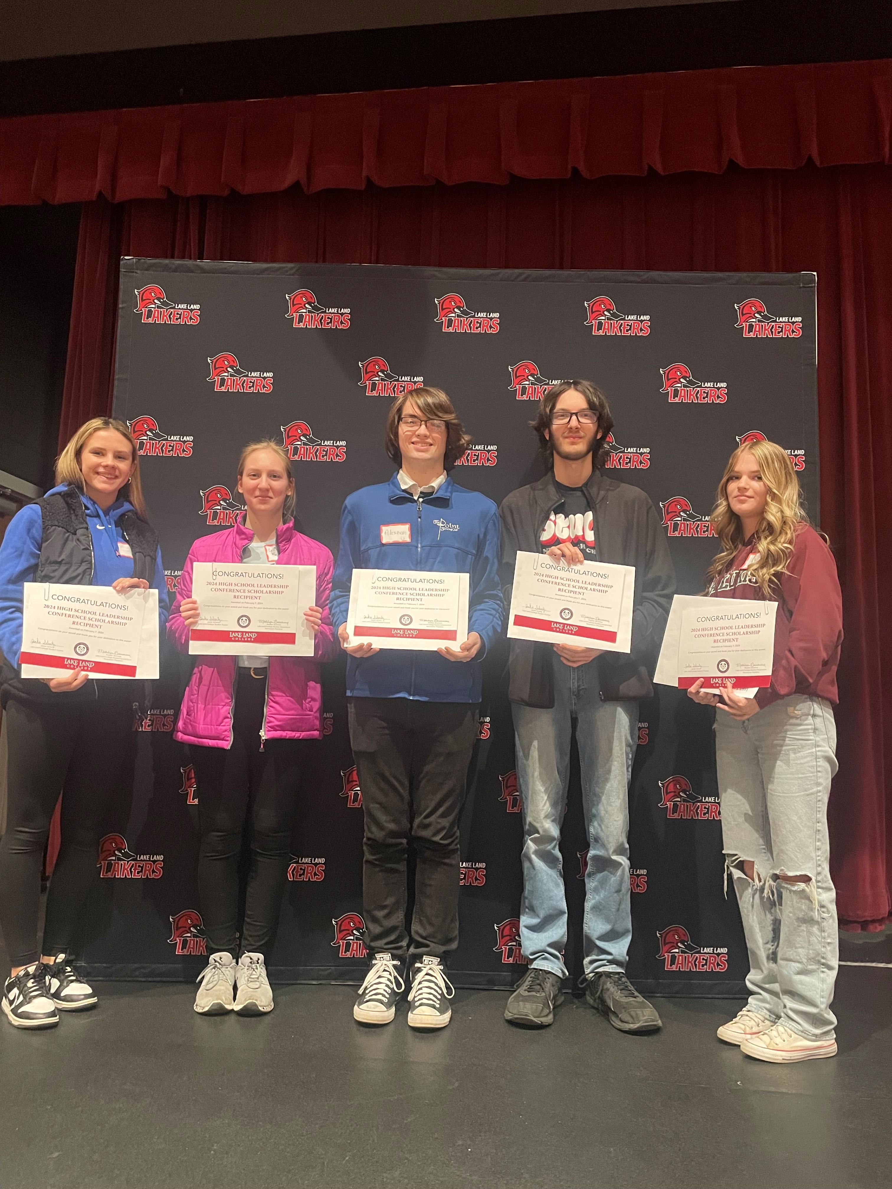 Five high school students pose with the 3 credit-hour tuition waivers they received at the High School Leadership Conference