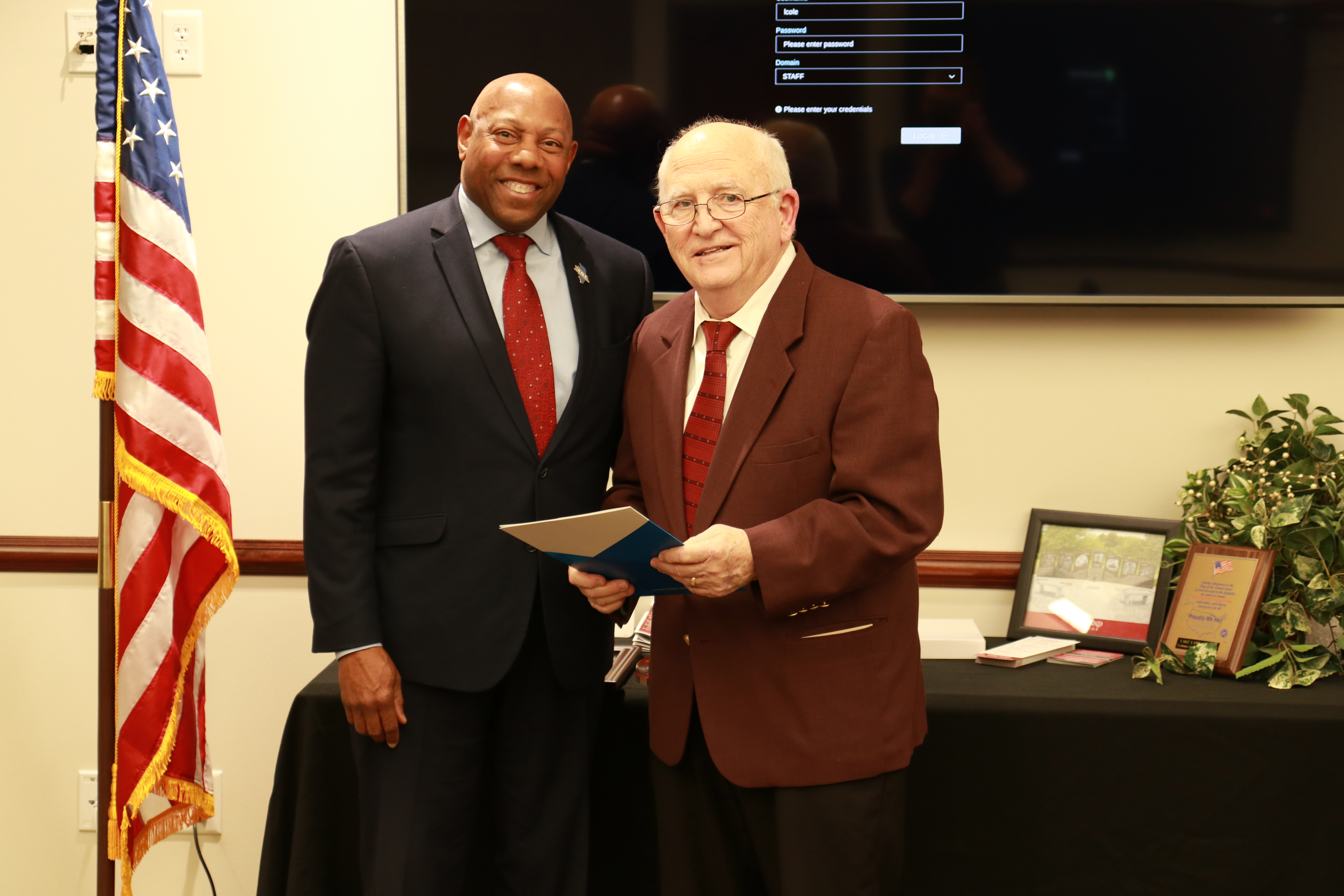 Two men, ICCTA Executive Director Jim Reed and former Lake Land College Trustee Mike Sullivan, standing together as Reed presents Sullivan an award. 