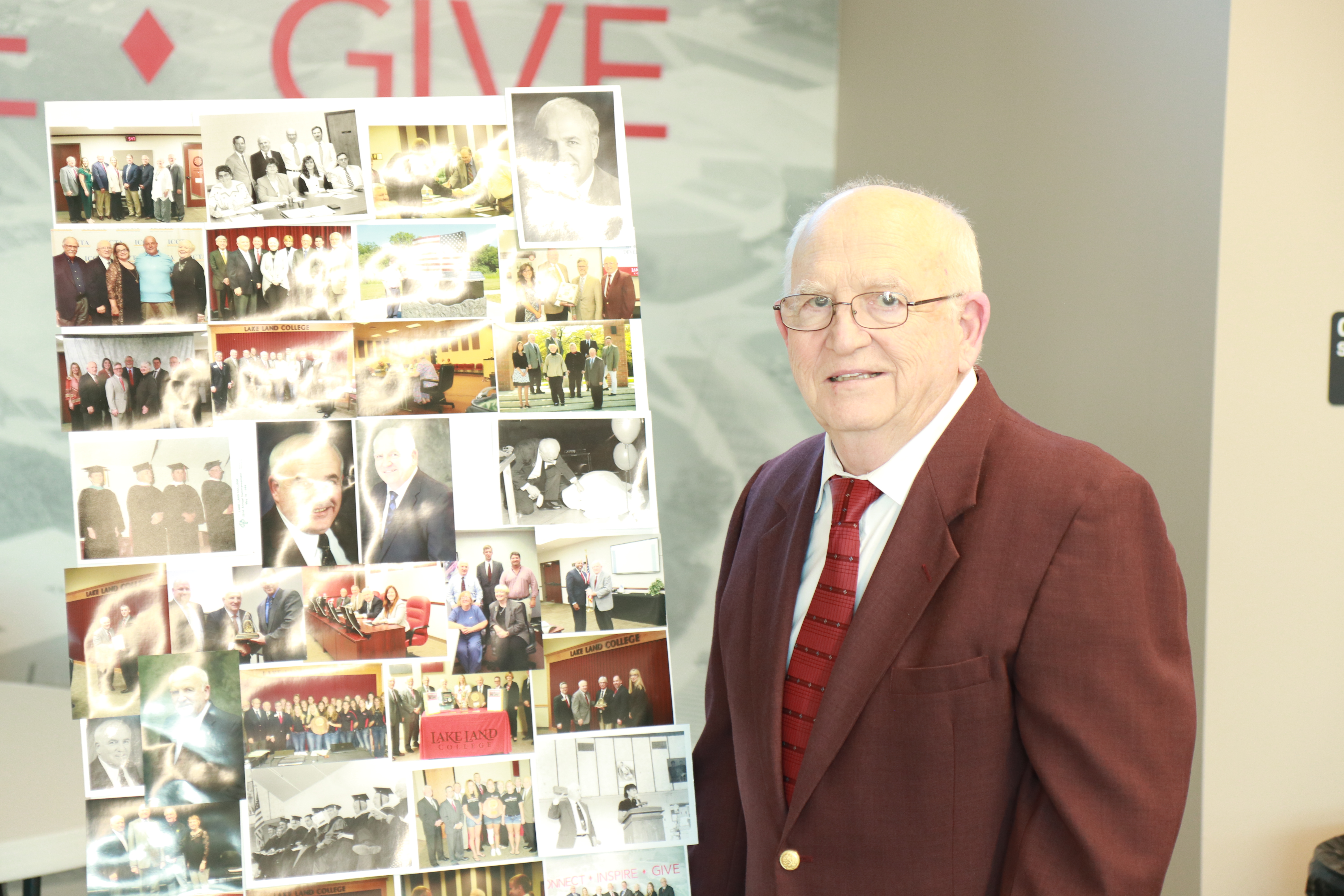 Mike Sullivan, a former Lake Land College Board of Trustee Member, standing next to a photo collage depicting his years of service at Lake Land College. 