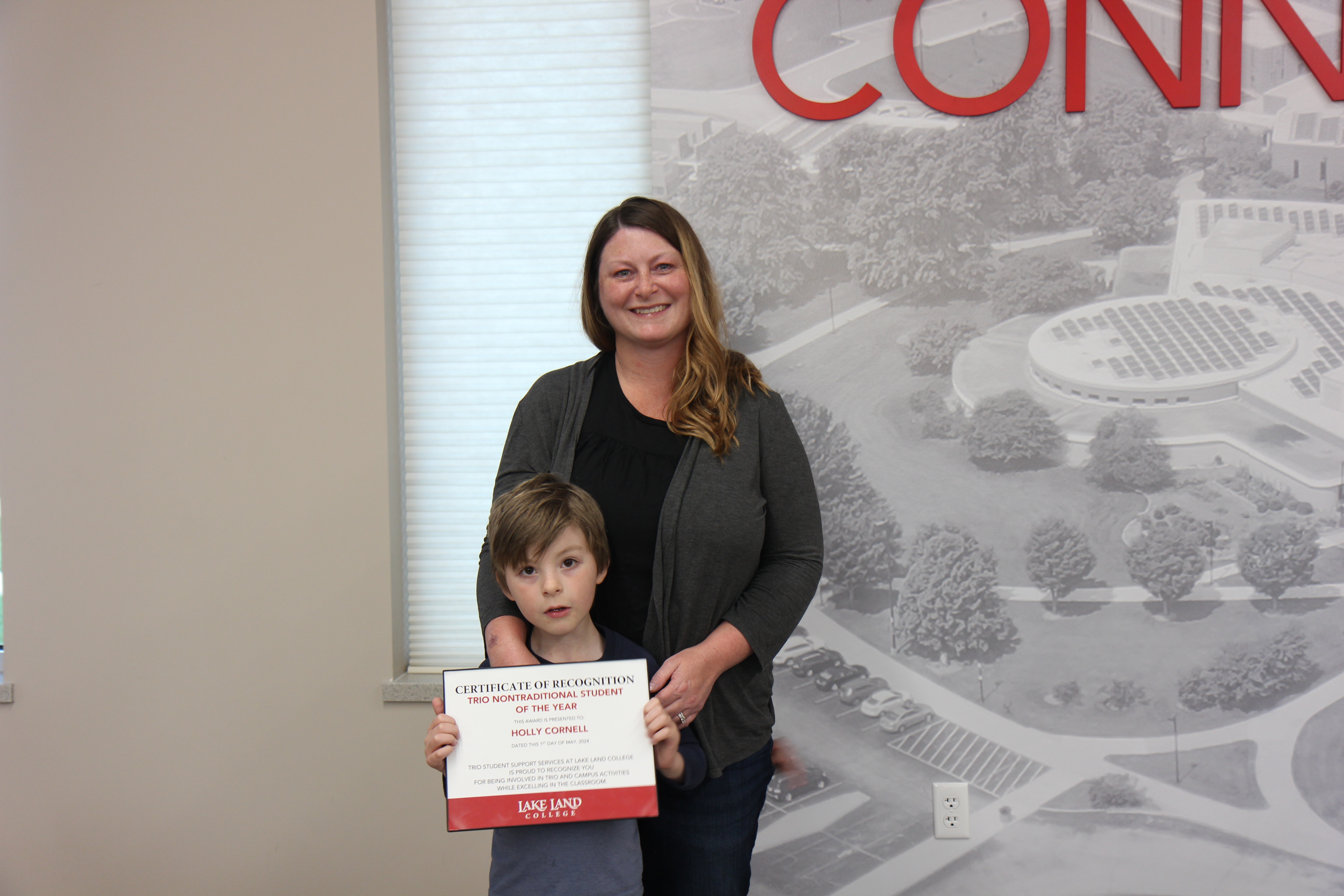 A Lake Land College student holding an award.