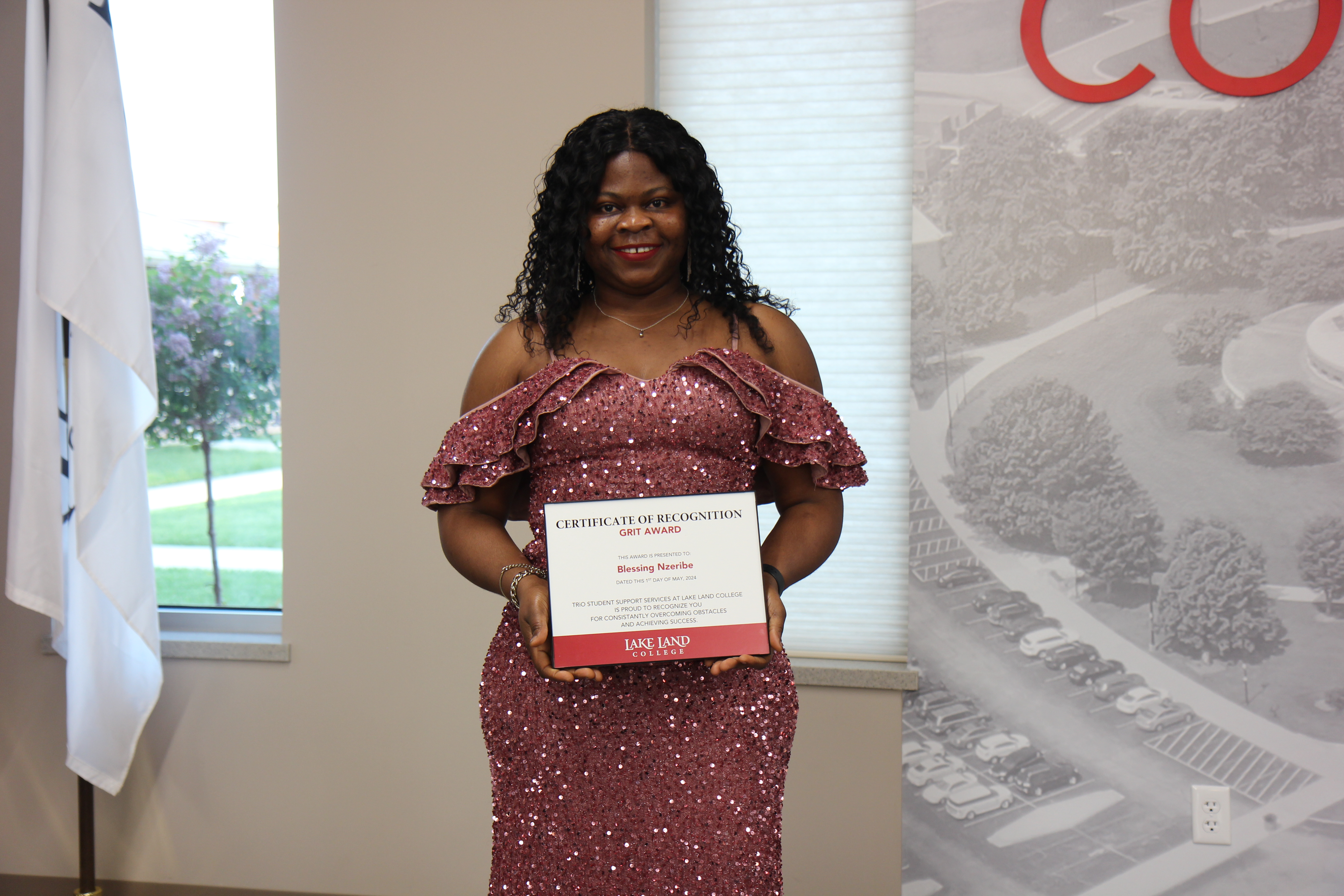 A Lake Land College TRIO Student holding an award