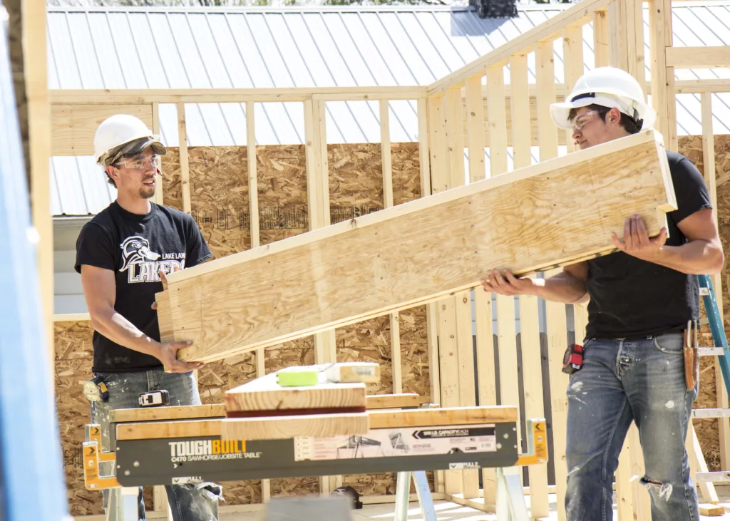 Two guys building a structure out of wood