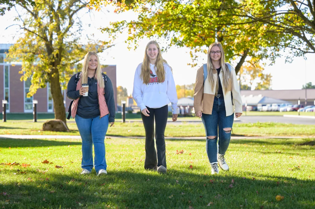 Students happily walking across the grass