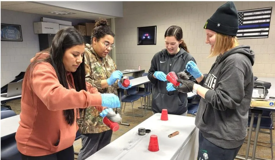 Students fingerprint dusting cups for a craft project