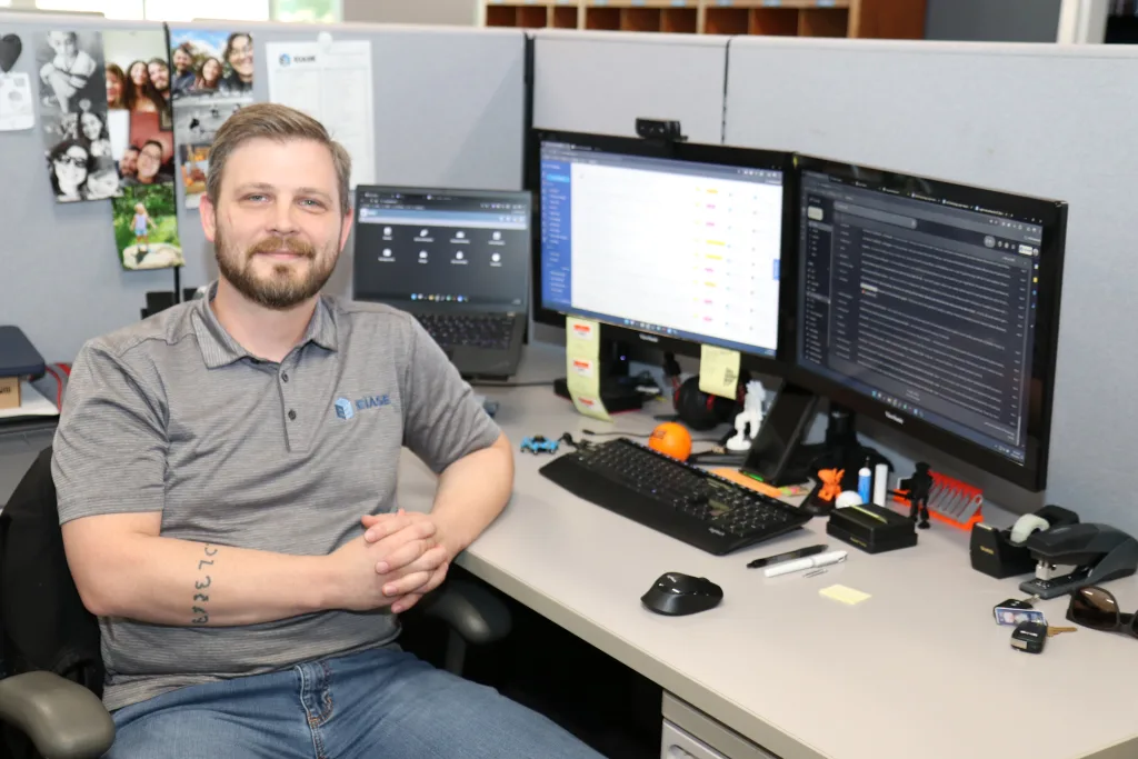 Man sitting at a desk posing in front of a computer