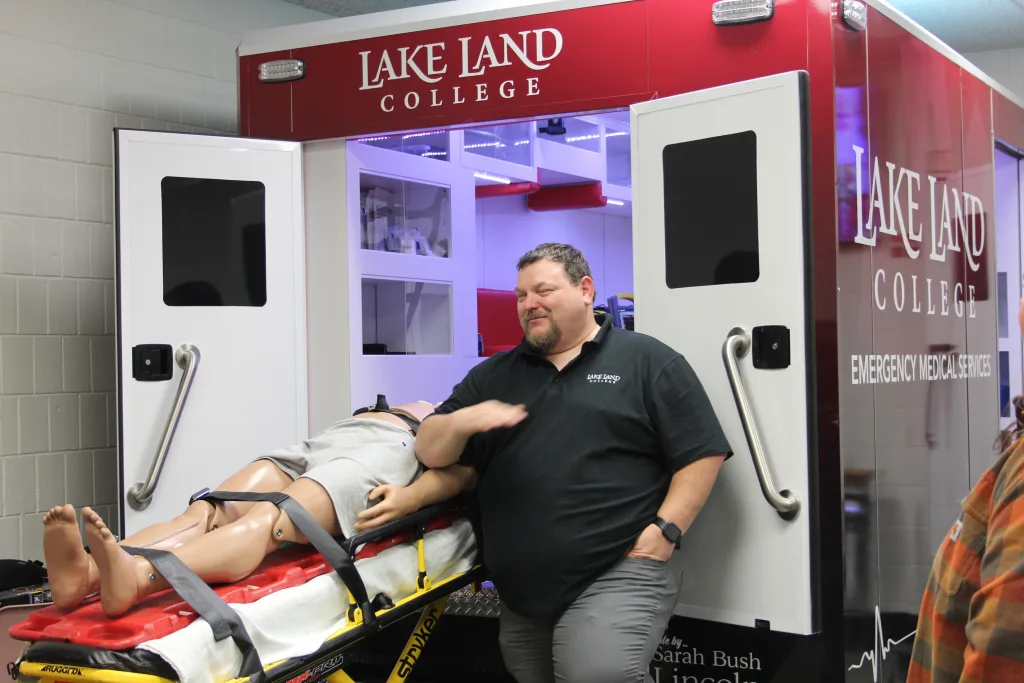 Someone loading a dummy on stretcher into an ambulance