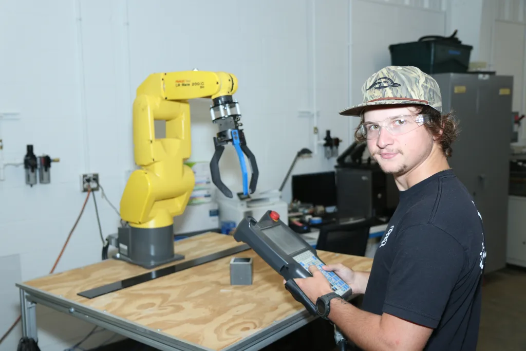 Student working with robotic arm machine