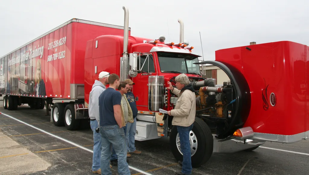 Students looking under the hood of a semi truck