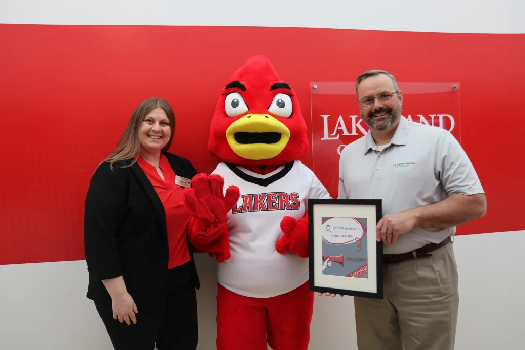 Two people holding an award with Laker Louie