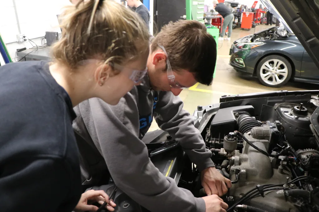 Students working on car engine
