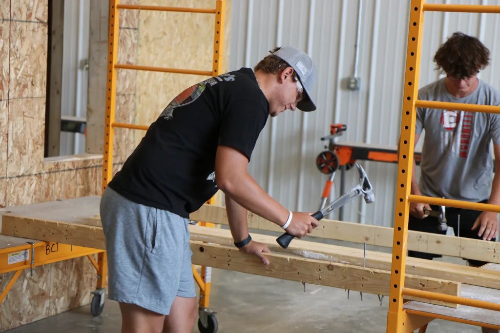 Students working with wood and hammer