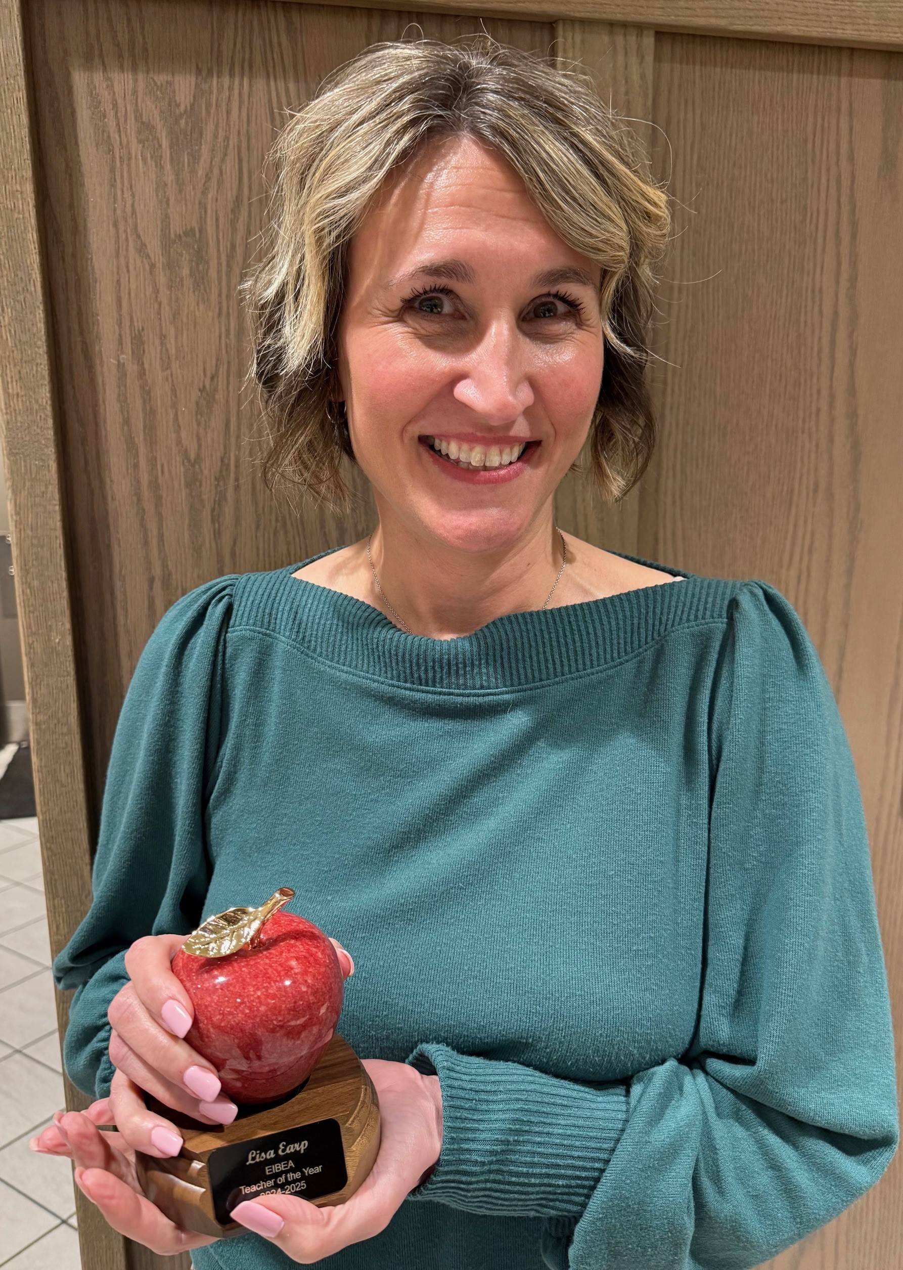 An instructor holding an award she received