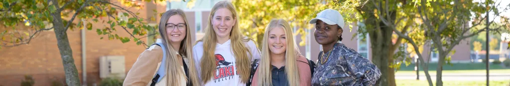Four students gathered together and smiling
