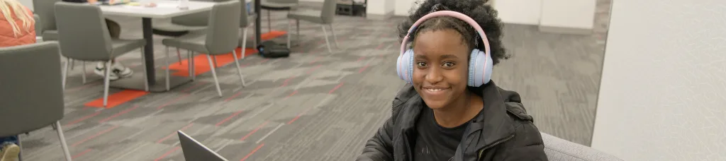 A student in a common area smiling