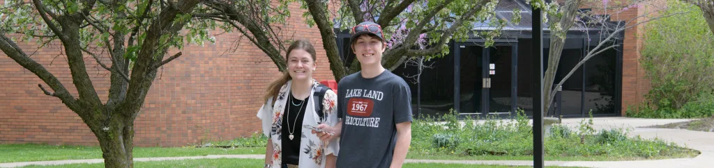 Two students standing together and smiling