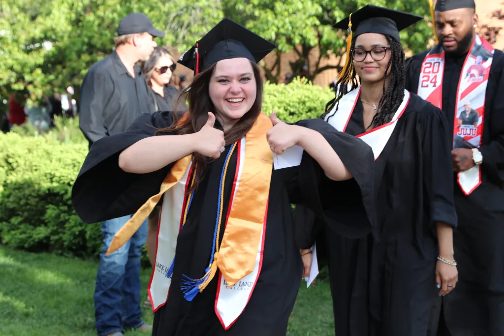 Graduate showing two thumbs up