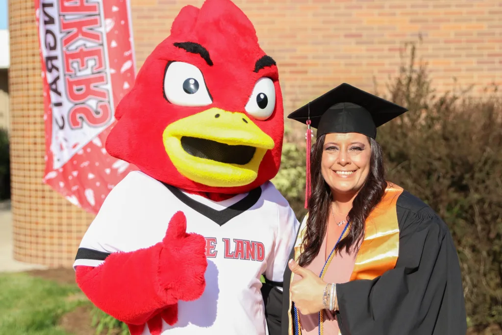 Graduate smiling with Laker Louie