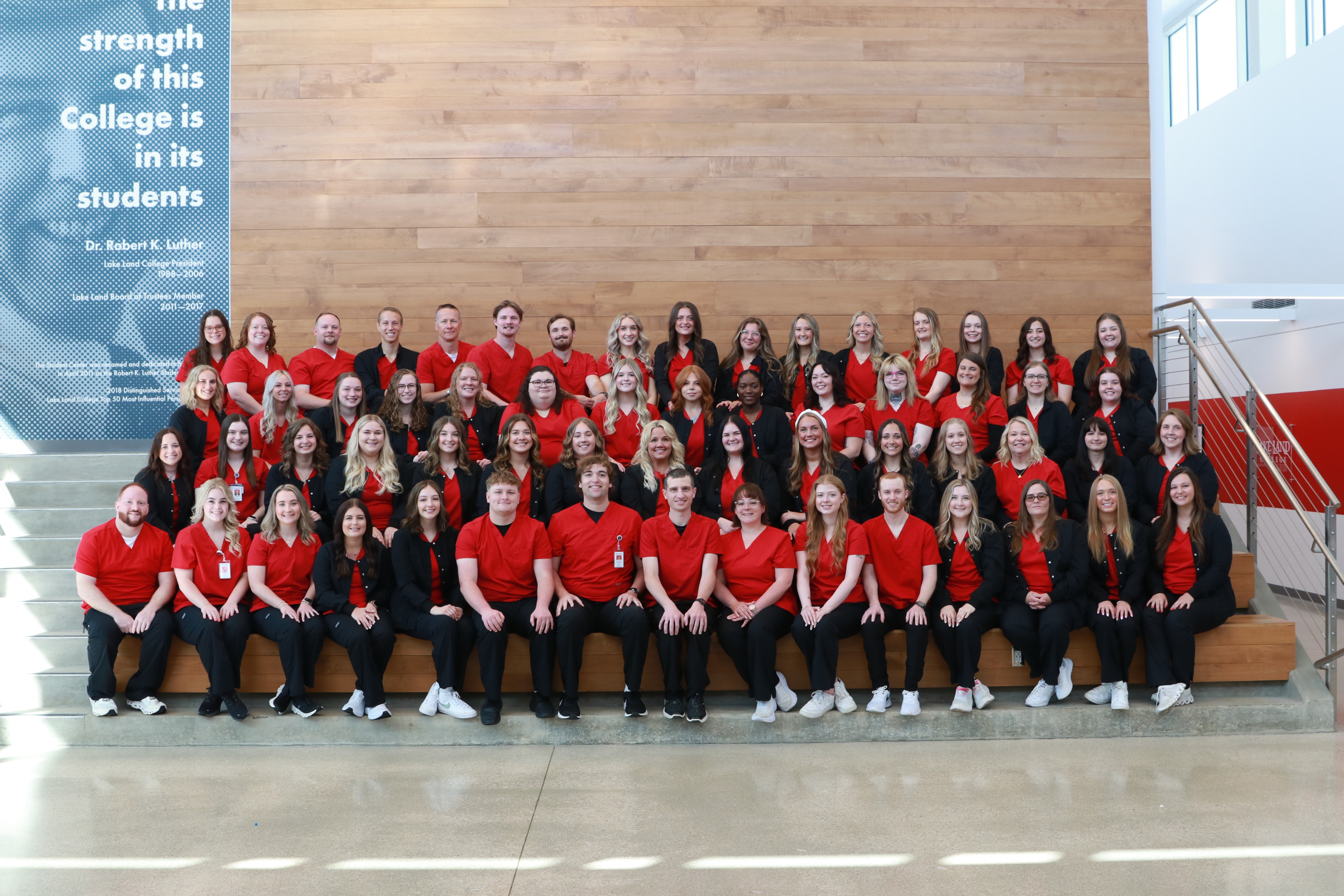 Nursing graduates sitting together for a group photo.
