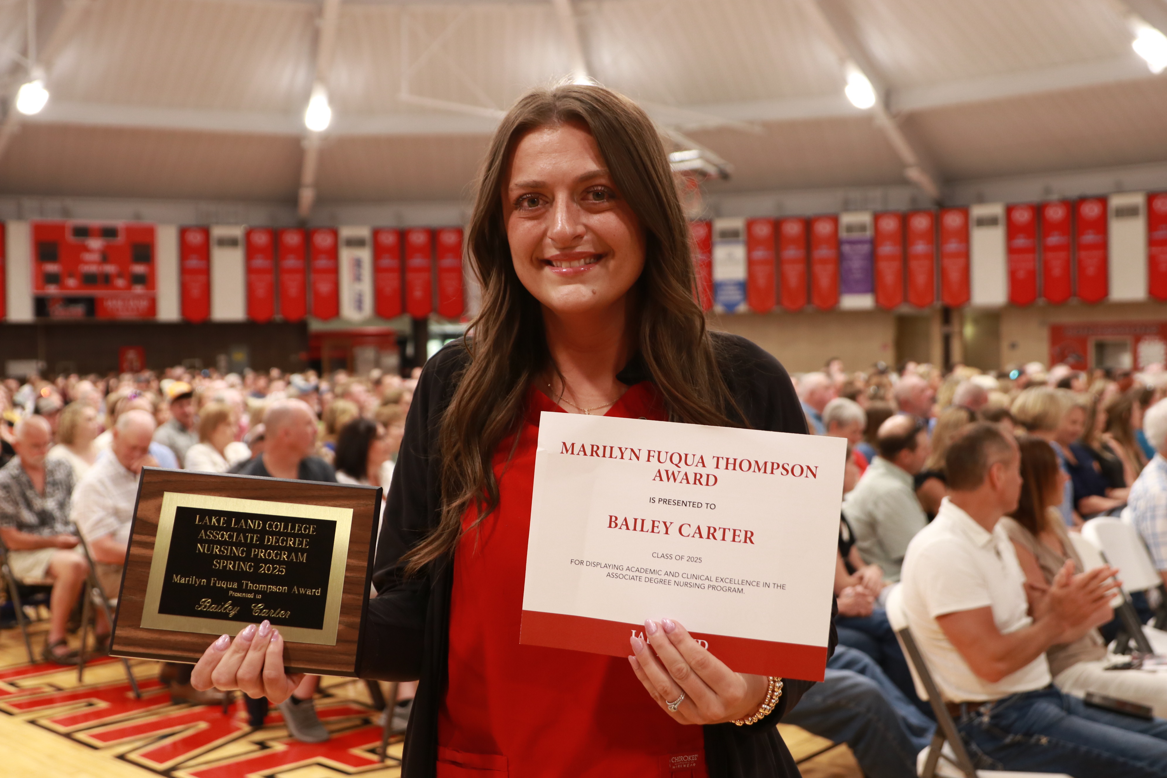 A Nursing graduate with an award during a ceremony.