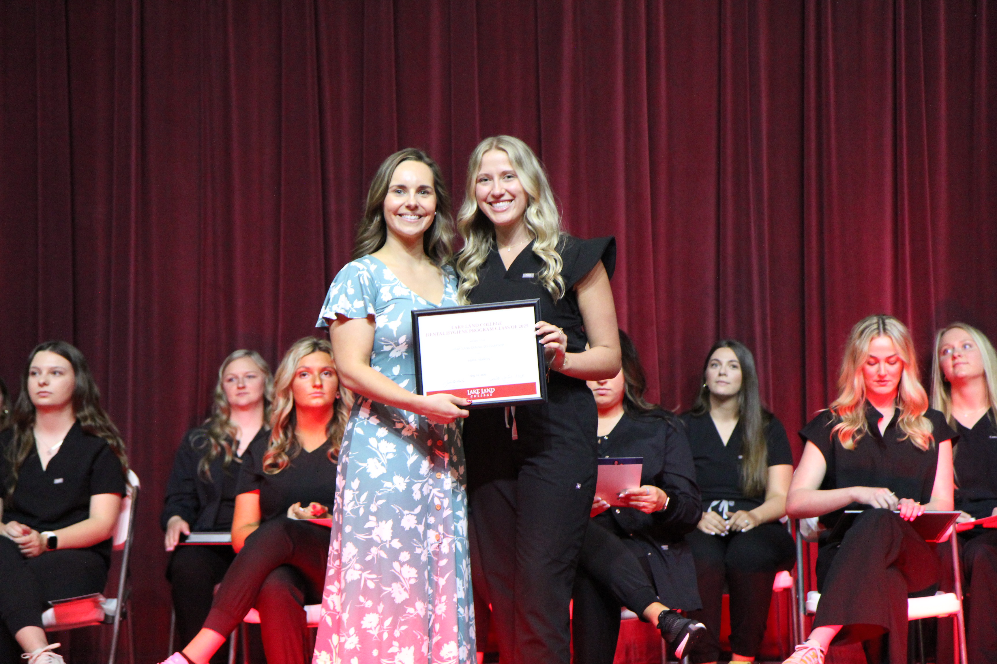 A Lake Land College Dental Hygiene instructor presenting an award to a graduating student during an annual pinning ceremony. 