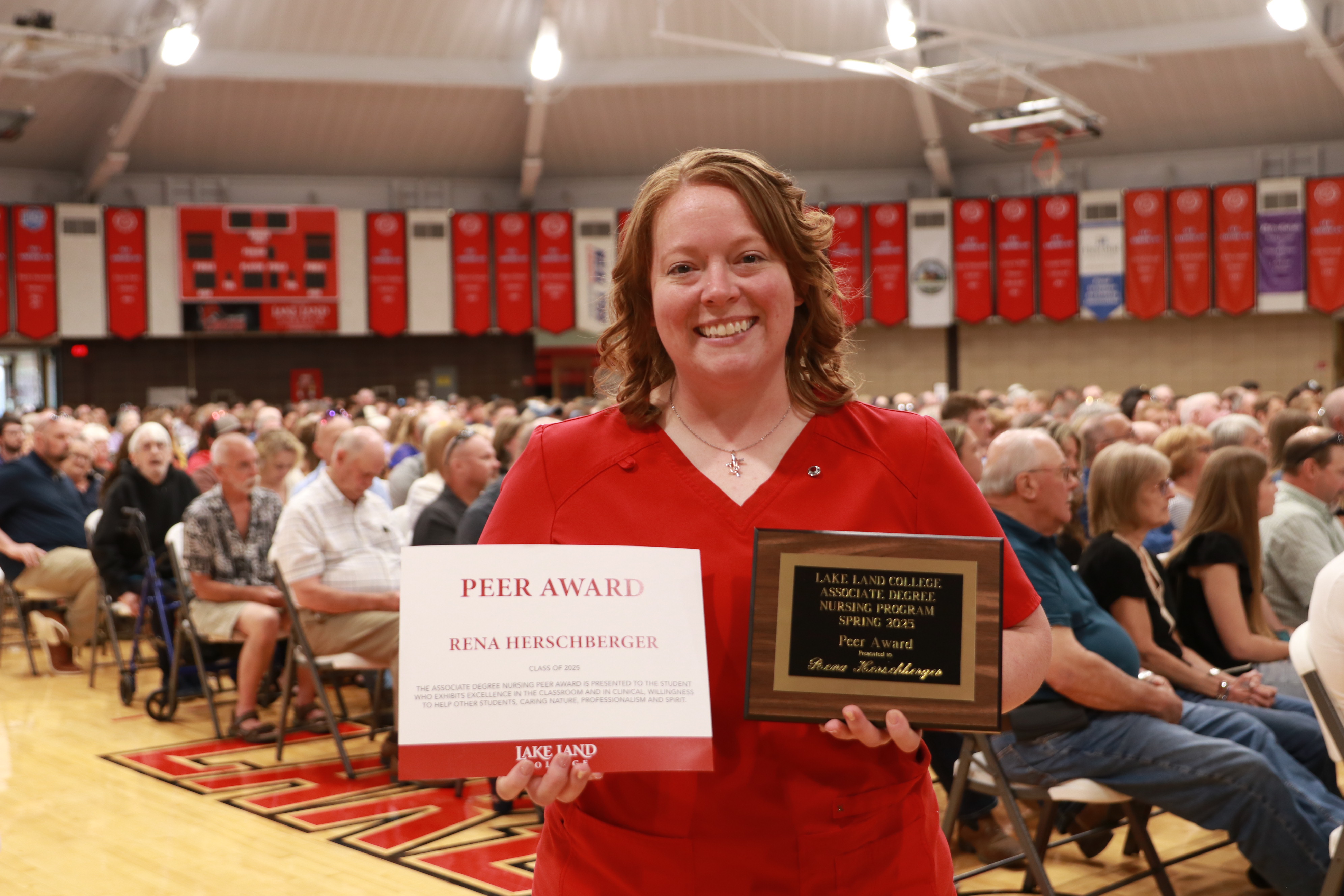 A Nursing graduate with an award during a ceremony.