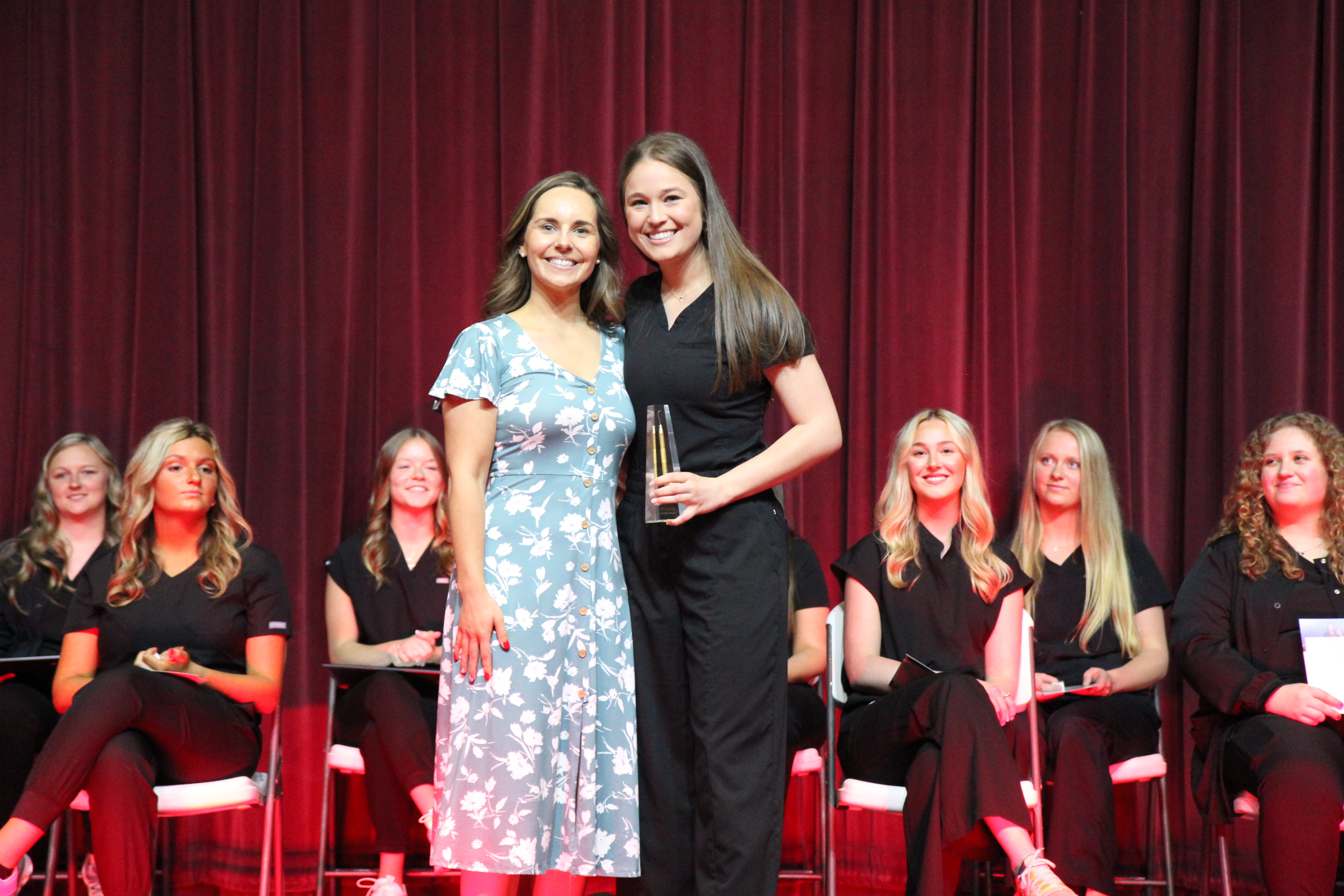 A Lake Land College Dental Hygiene instructor presenting an award to a graduating student during a pinning ceremony. 