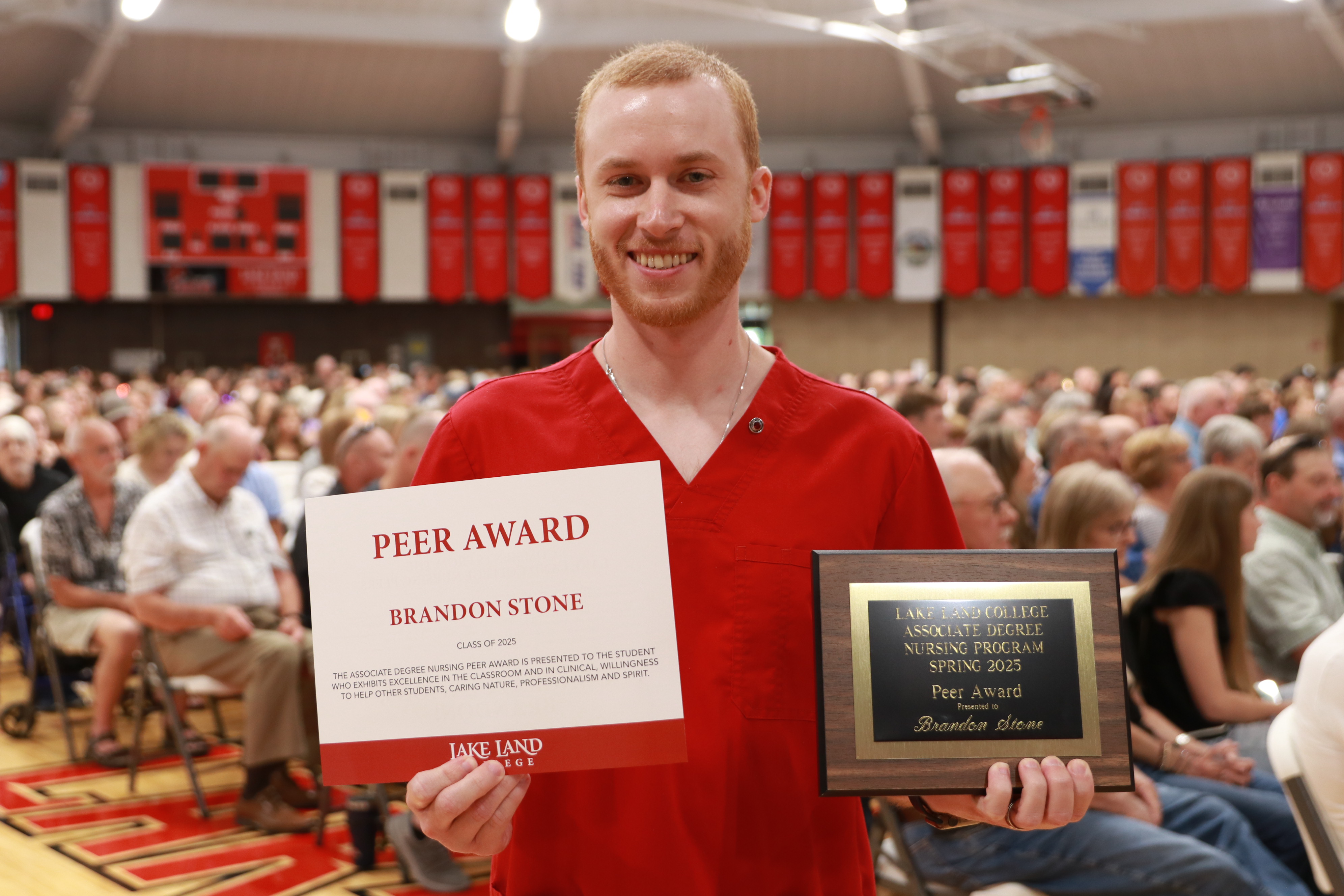 A Nursing graduate with an award during a ceremony.