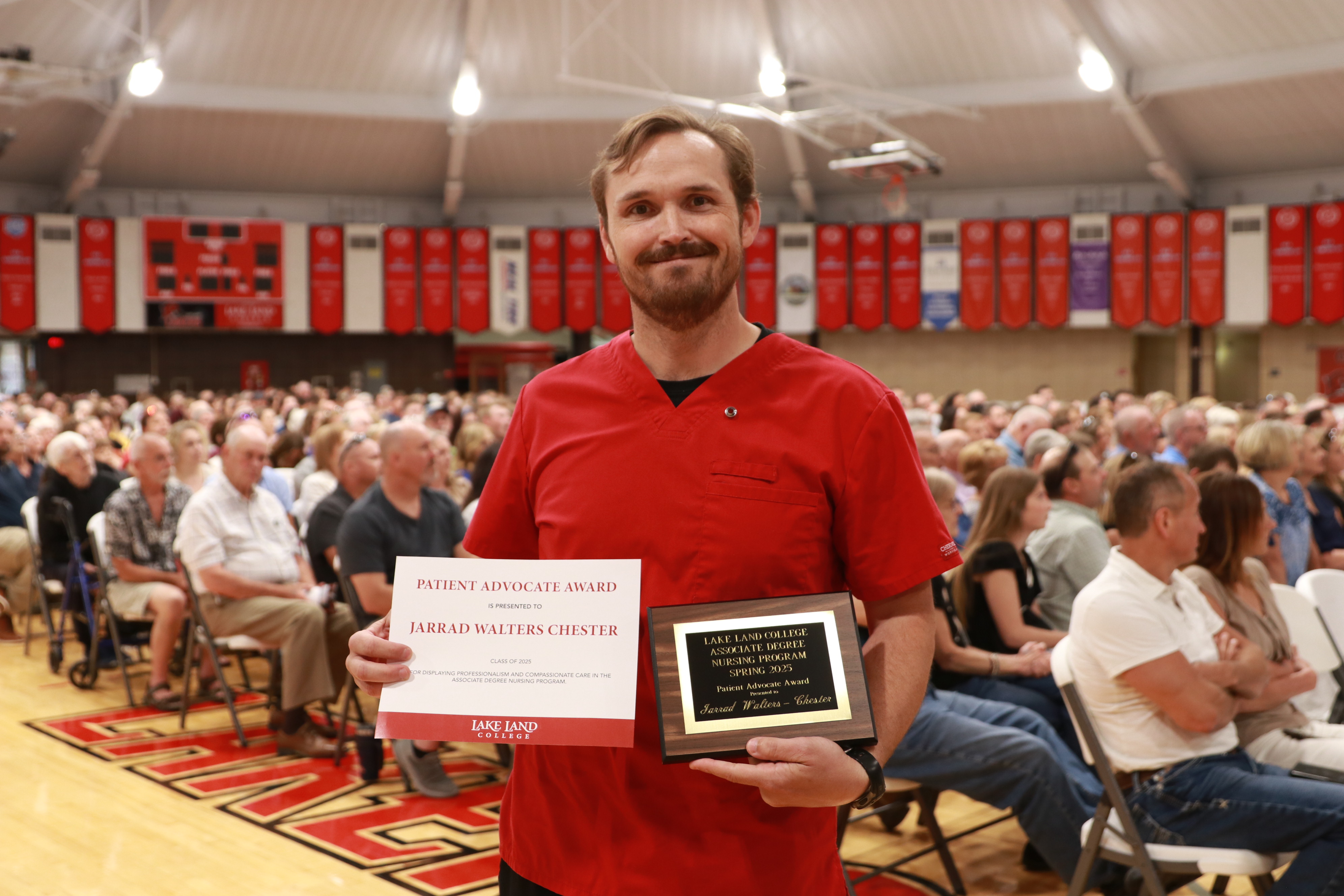 A Nursing graduate with an award during a ceremony.