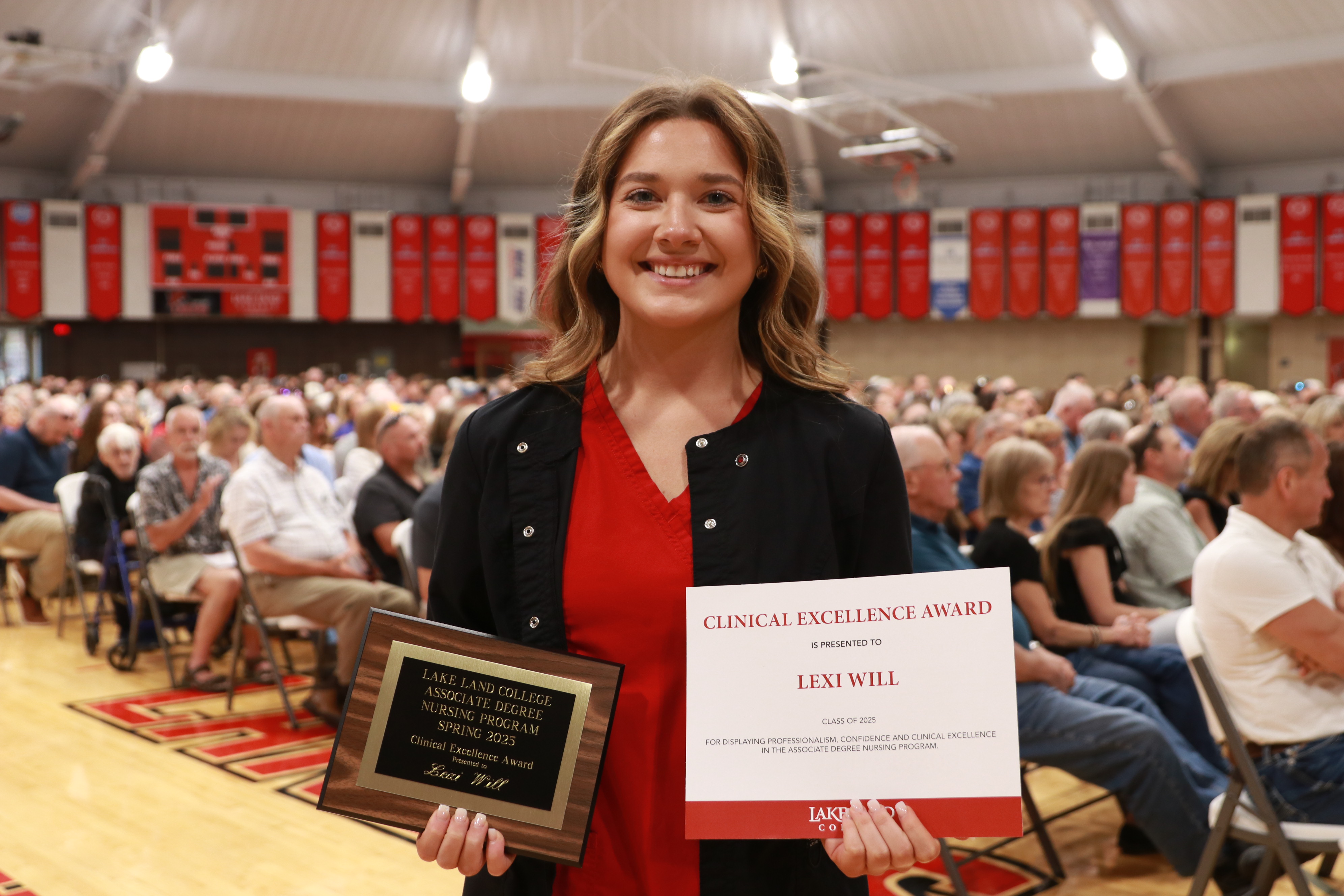 A Nursing graduate with an award during a ceremony.