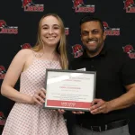 Two people posing for a photo holding a certificate