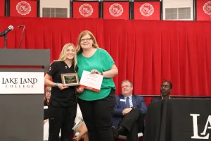 A Medical Assistant program graduate receiving an award during a pinning ceremony.