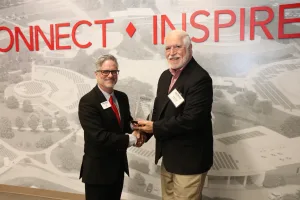 Lake Land College President Josh Bullock presents the Retiree Wall of Fame honor to John Bennett during the 2025 Lake Land College Foundation and Alumni Awards reception.