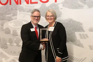 Lake Land College President Josh Bullock presents the Retiree Wall of Fame honor to Dr. Tina Stovall during the 2025 Lake Land College Foundation and Alumni Awards reception.