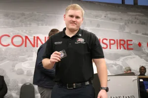 EMS graduate Peyton Daugherty with an award he received during the Fall 2025 EMS Pinning Ceremony.