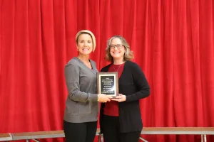 Librarian/Director of Library Services Sarah Hill presenting the 2026 LLCFA Outstanding Service Faculty Award to Communications Studies Instructor Eva Ritchey during the Lake Land College employee recognition event.