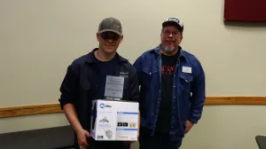 An image of Lake Land College Welding Instructor/Program Coordinator James Crowder presenting the 3rd Place Junior award to Michael Althoff, Teutopolis High School, during the first-ever Laker Connect Dual Credit High School Welding Competition.