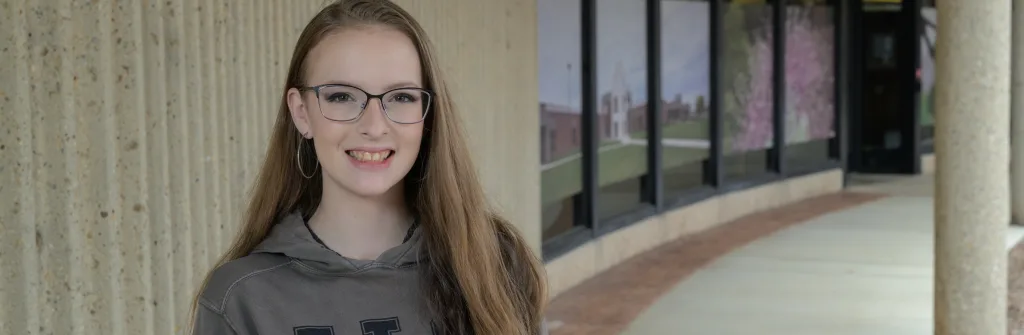 Photo of student in front of the library.