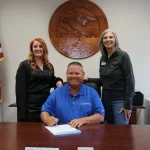 A photo of Lake Land College staff members Bonnie Moore and Lesa Allsop alongside Effingham Mayor Mike Schutzbach as he signs an official proclamation to recognize National Apprenticeship Week.