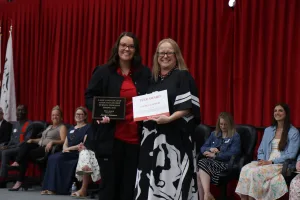 A nursing graduate receiving an award during a pinning ceremony.