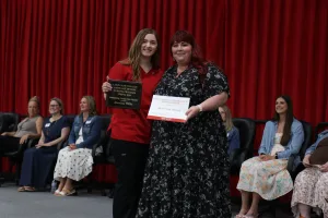 A nursing graduate receiving an award during a pinning ceremony.