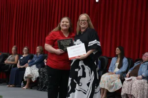 A nursing graduate receiving an award during a pinning ceremony.