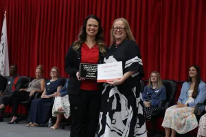 A nursing graduate receiving an award during a pinning ceremony.