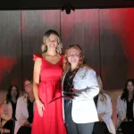 A dental hygiene graduate receiving an award from an instructor during a graduation ceremony.