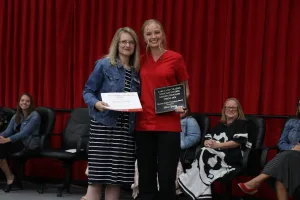 A nursing graduate receiving an award during a pinning ceremony.