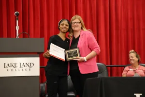 A medical assistant graduate receiving an award during the program's annual pinning ceremony.