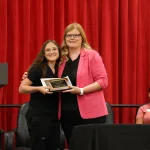 A medical assistant graduate receiving an award during the program's annual pinning ceremony.