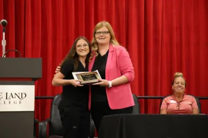 A medical assistant graduate receiving an award during the program's annual pinning ceremony.