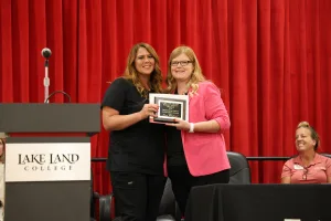 A medical assistant graduate receiving an award during the program's annual pinning ceremony.