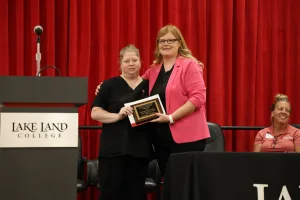 A medical assistant graduate receiving an award during the program's annual pinning ceremony.